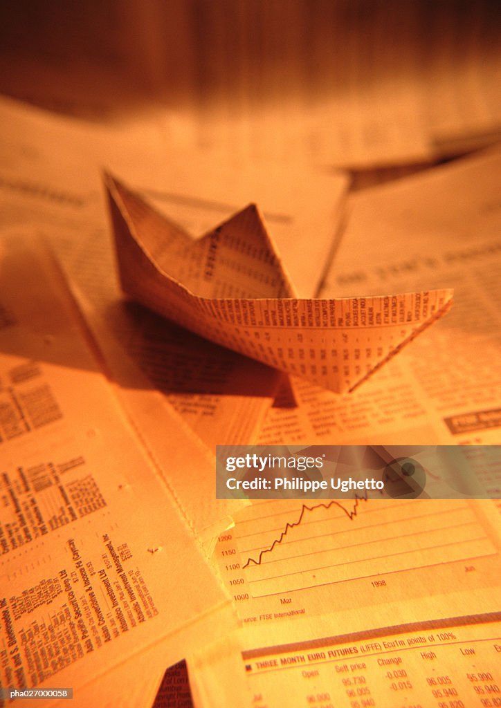 Paper boat made from financial documents, close-up