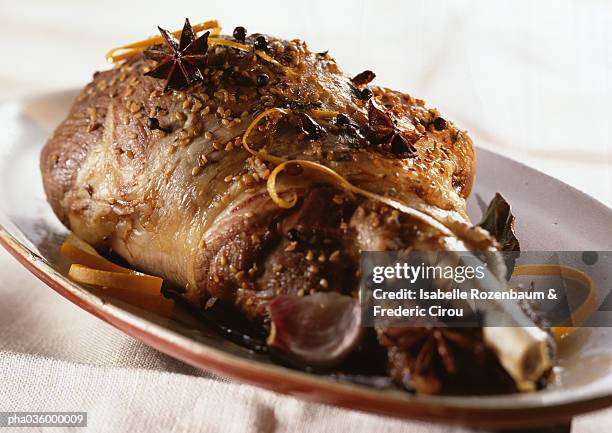 leg of lamb with spices and zest on dish, close-up - gigot stock-fotos und bilder
