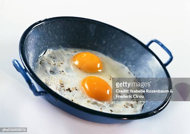 fried eggs with two unbroken egg yolks in wok - egg ストックフォトと画像