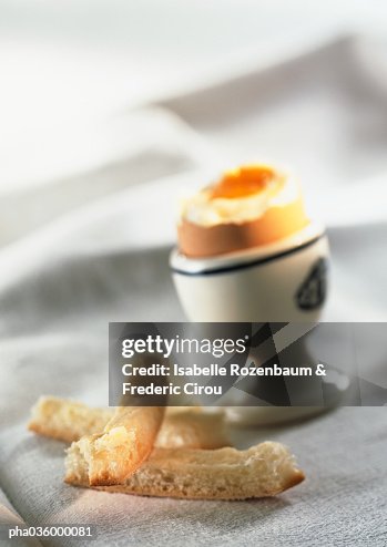 Soft-boiled egg in eggcup, blurred, with bread crusts Soft-boiled egg in eggcup, blurred, with bread crusts