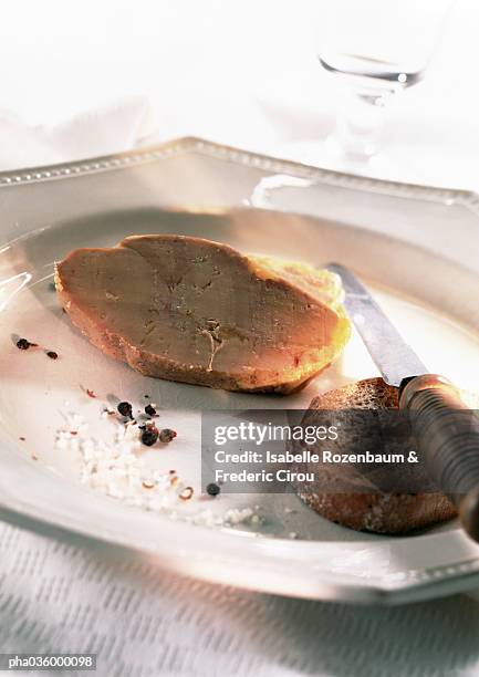 foie gras, slice of bread, knife, and crumbs on plate, close-up - bread knife stockfoto's en -beelden