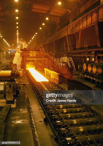 molten steel in rolling mill, long shot - steelmaking stock pictures, royalty-free photos & images
