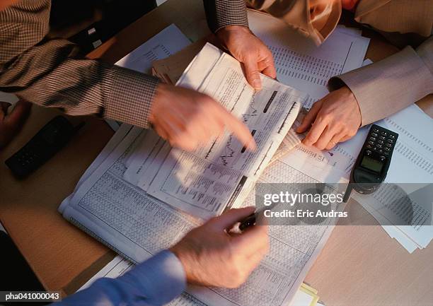 hands pointing at documents - share prices of consumer companies pushes dow jones industrials average sharply higher stockfoto's en -beelden