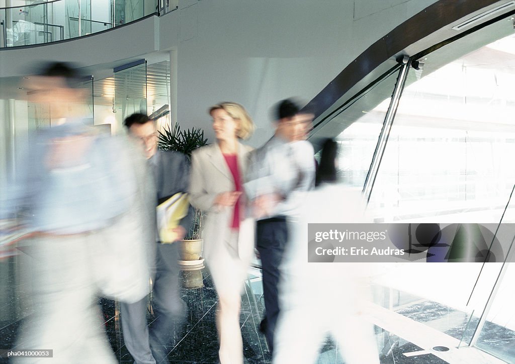 People walking inside office building, blurred