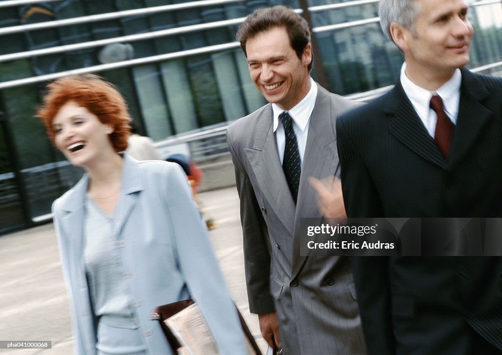 Three business people walking outside