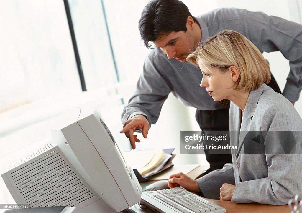 Businessman and businesswoman looking at computer screen