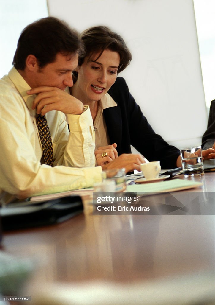 Businessman and businesswoman sitting at desk