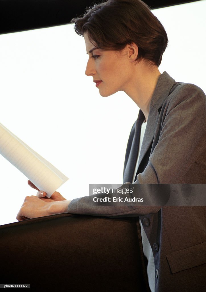 Businesswoman reading document, side view