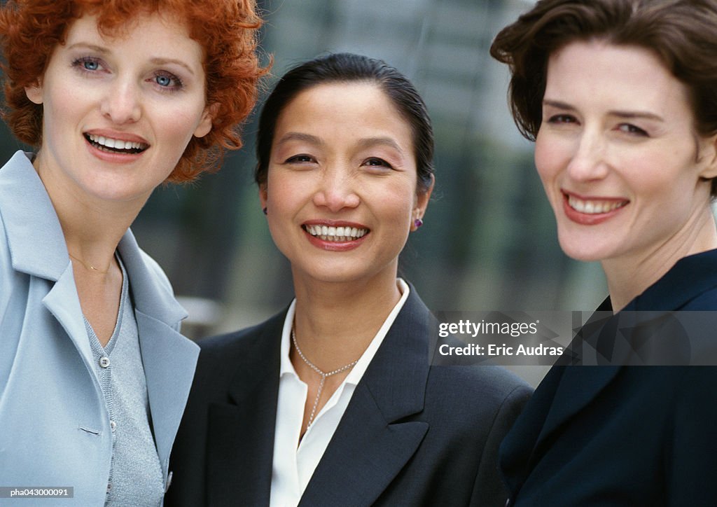 Three businesswomen side by side, smiling