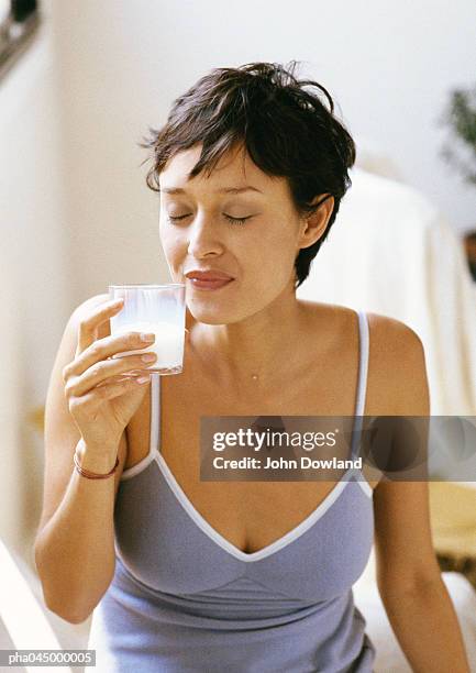 woman holding glass, eyes closed, waist up, close-up - woman drinking milk stock pictures, royalty-free photos & images