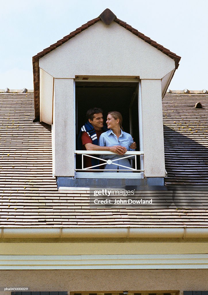 Couple standing at window