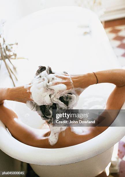 person in bathtub, shampooing hair, rear view - femme shampoing photos et images de collection