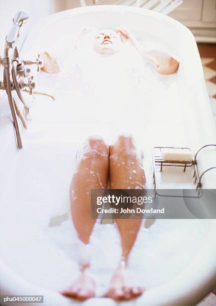 woman taking bubble bath, high angle view, blurred - beautiful woman bath stock-fotos und bilder