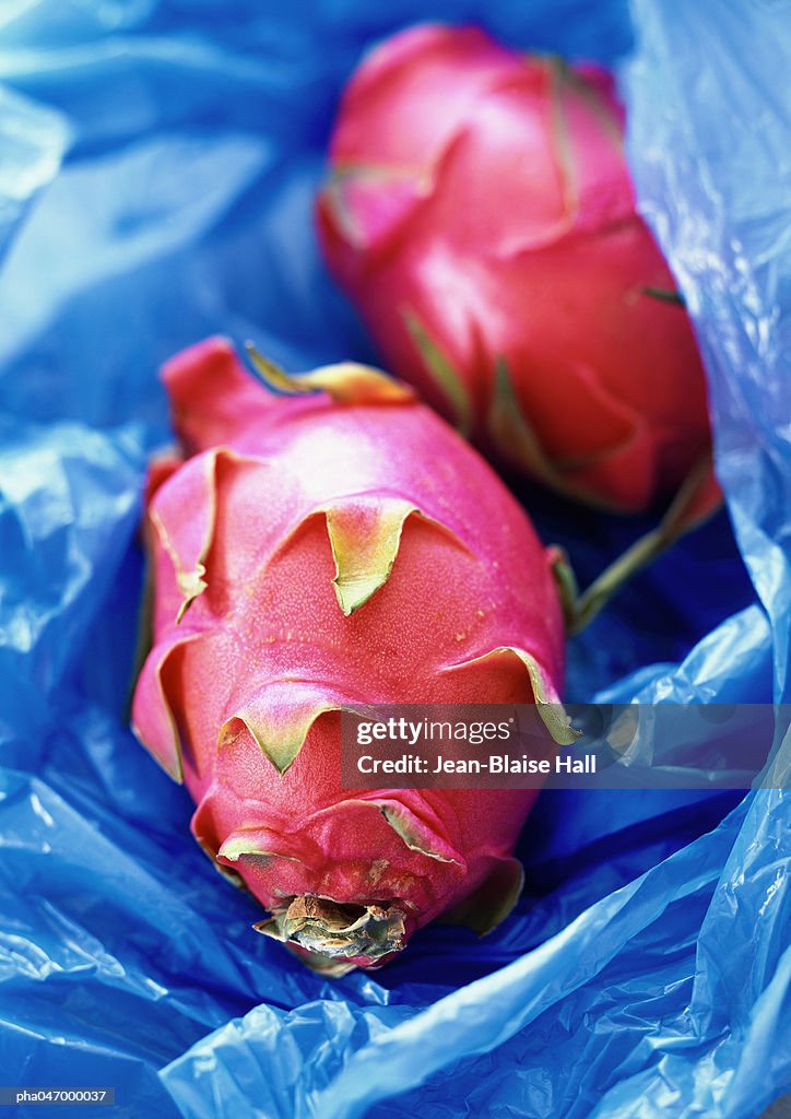 Red pitayas on blue plastic, close-up