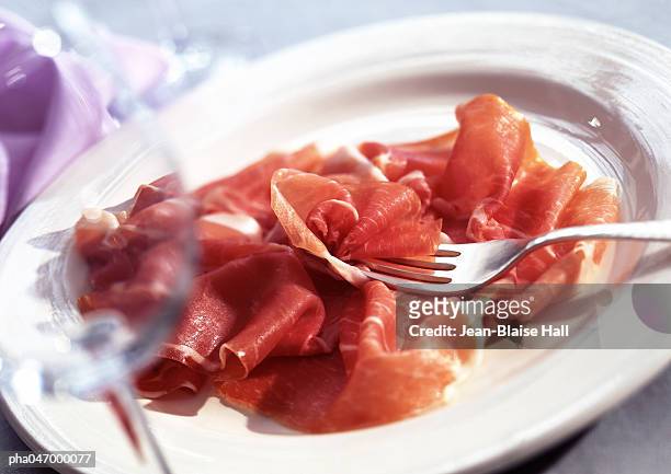 plate of parma ham with fork, close-up - jambon de parme photos et images de collection