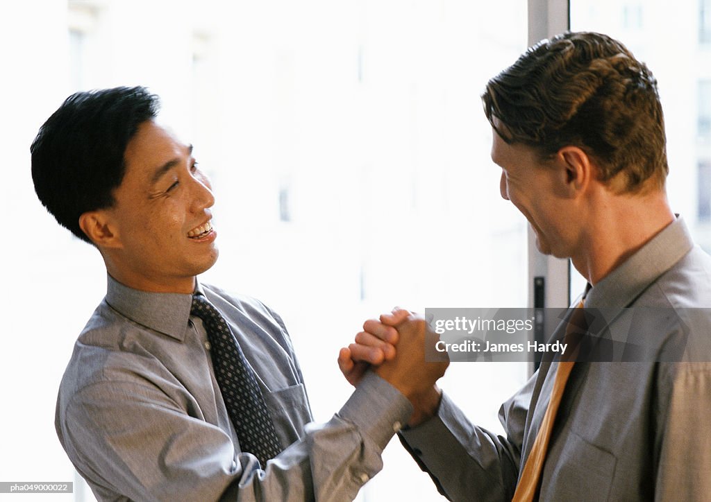 Two men shaking hands, side view