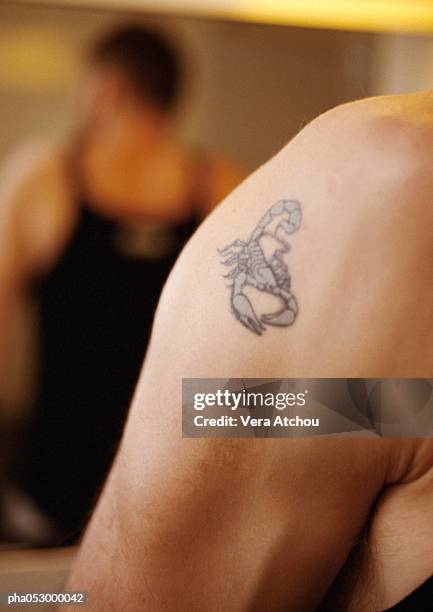 scorpion tattoo on man's shoulder, close-up - arachnid stockfoto's en -beelden