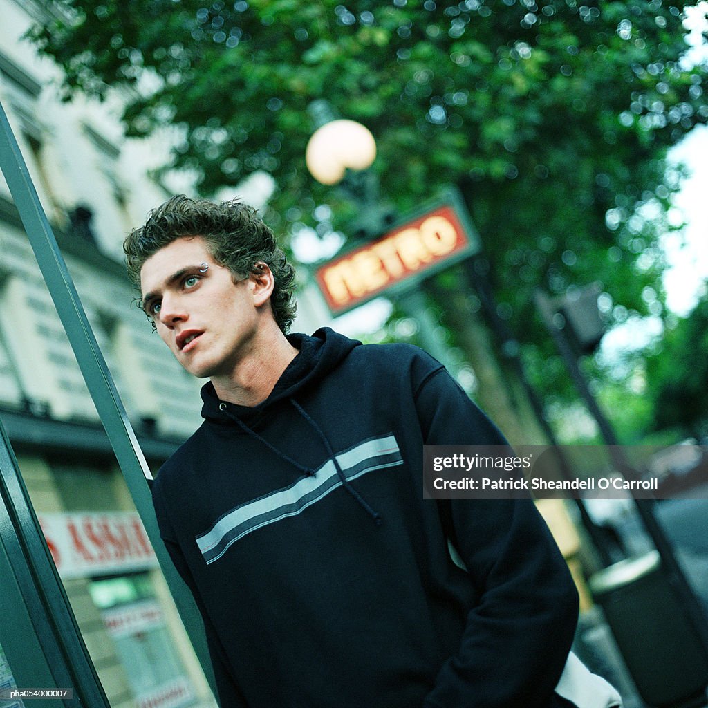 Male teenager under a blurred subway sign