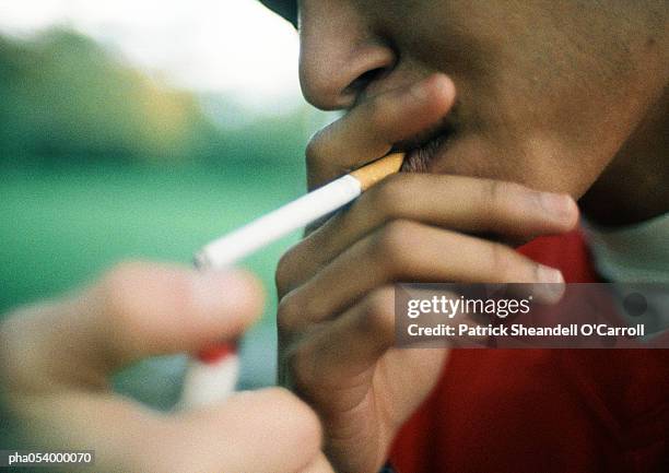 teenager lighting cigarette, close-up - cigarette lighter stockfoto's en -beelden