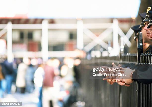 police standing behind railings, partial side view, crowd in background, blurred - intersected stock pictures, royalty-free photos & images