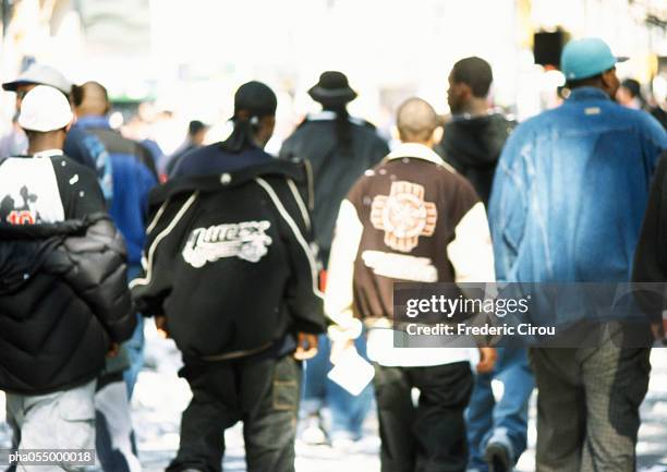 four men walking side by side, rear view, blurred - africain stockfoto's en -beelden