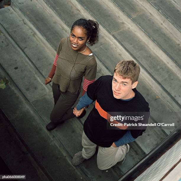 young couple walking downstairs looking up, high angle view - africain stockfoto's en -beelden
