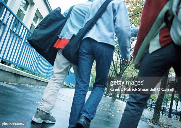 young people walking down sidewalk, lower section , rear view - gang stock pictures, royalty-free photos & images