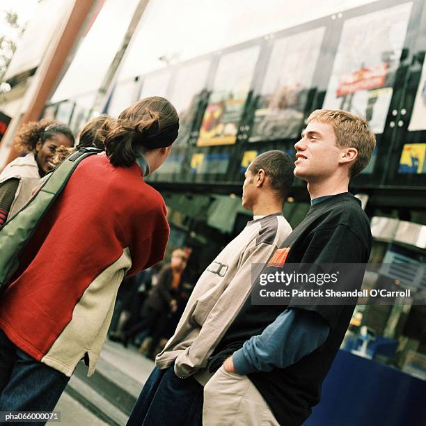 group of young people hanging out in front of movie theater - the uptown theater stock pictures, royalty-free photos & images