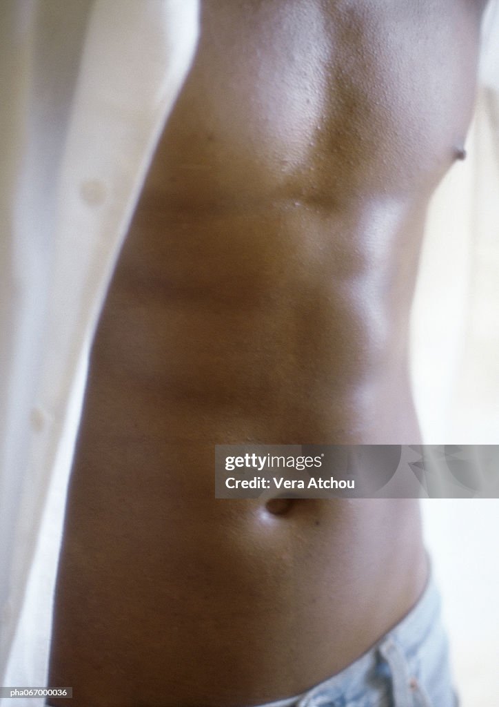 Man standing with shirt open, close up of torso