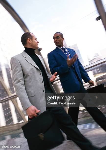 businessmen walking together inside, bulidings through window in background - africain stockfoto's en -beelden