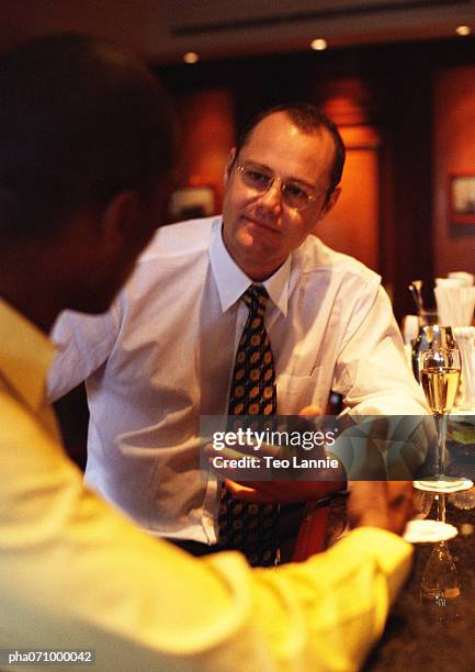 businessmen sitting at bar talking. - africain stockfoto's en -beelden