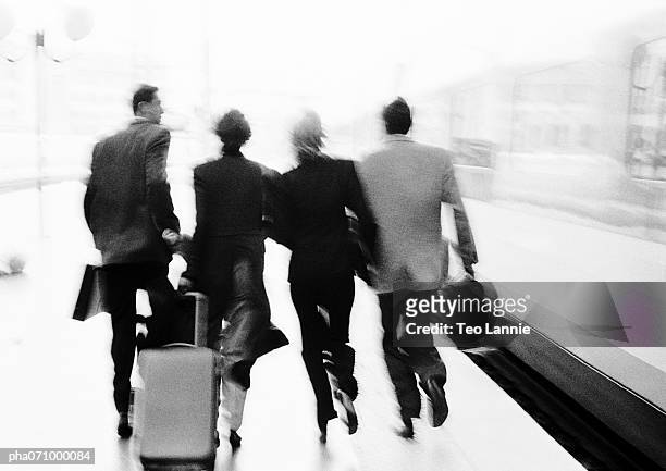 group of business people walking near train, rear view, blurred, b&w. - congo dr v mali 2013 africa cup of nations group b stockfoto's en -beelden