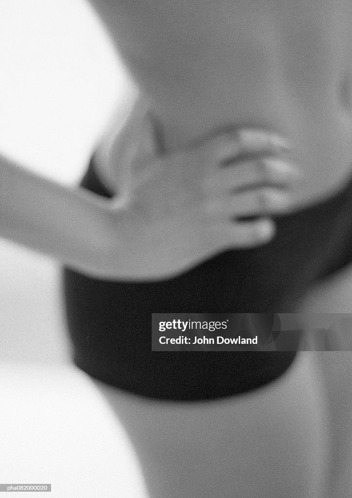 Woman with hand on hip, mid-section, blurred, close-up, B&W.