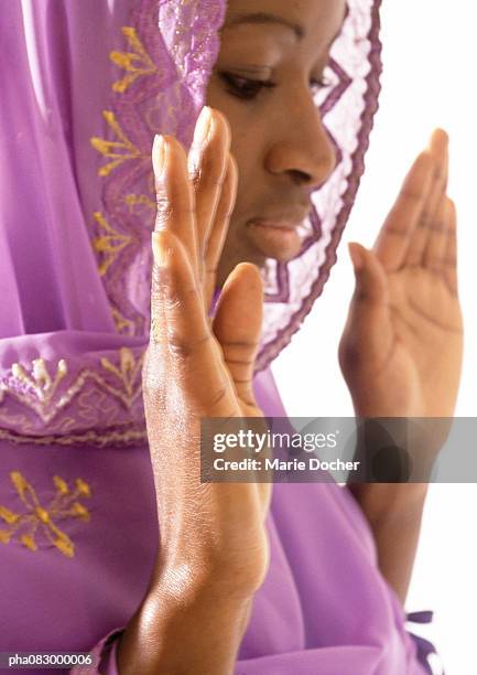 woman wearing veil holding hands up in prayer, close-up - africain stockfoto's en -beelden