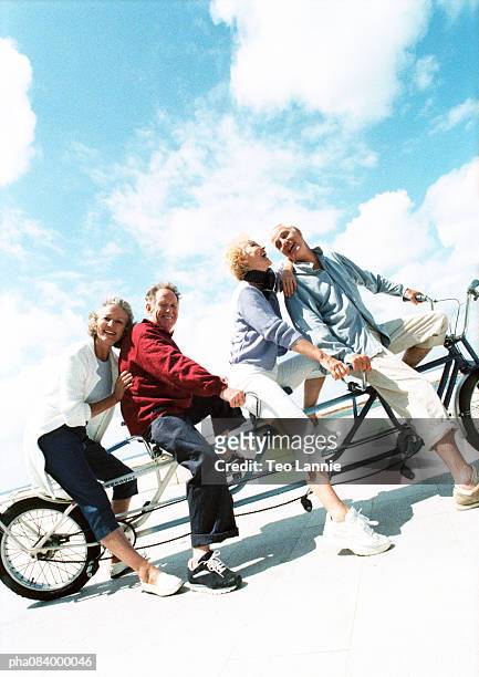 senior couples on tandem bike at beach, portrait. - tandem bicycle stock pictures, royalty-free photos & images
