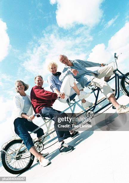 senior couples on tandem bike at beach, portrait. - travel12 stock pictures, royalty-free photos & images