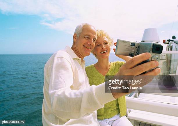 senior couple taking pictures of themselves on boat. - travel12 stock pictures, royalty-free photos & images