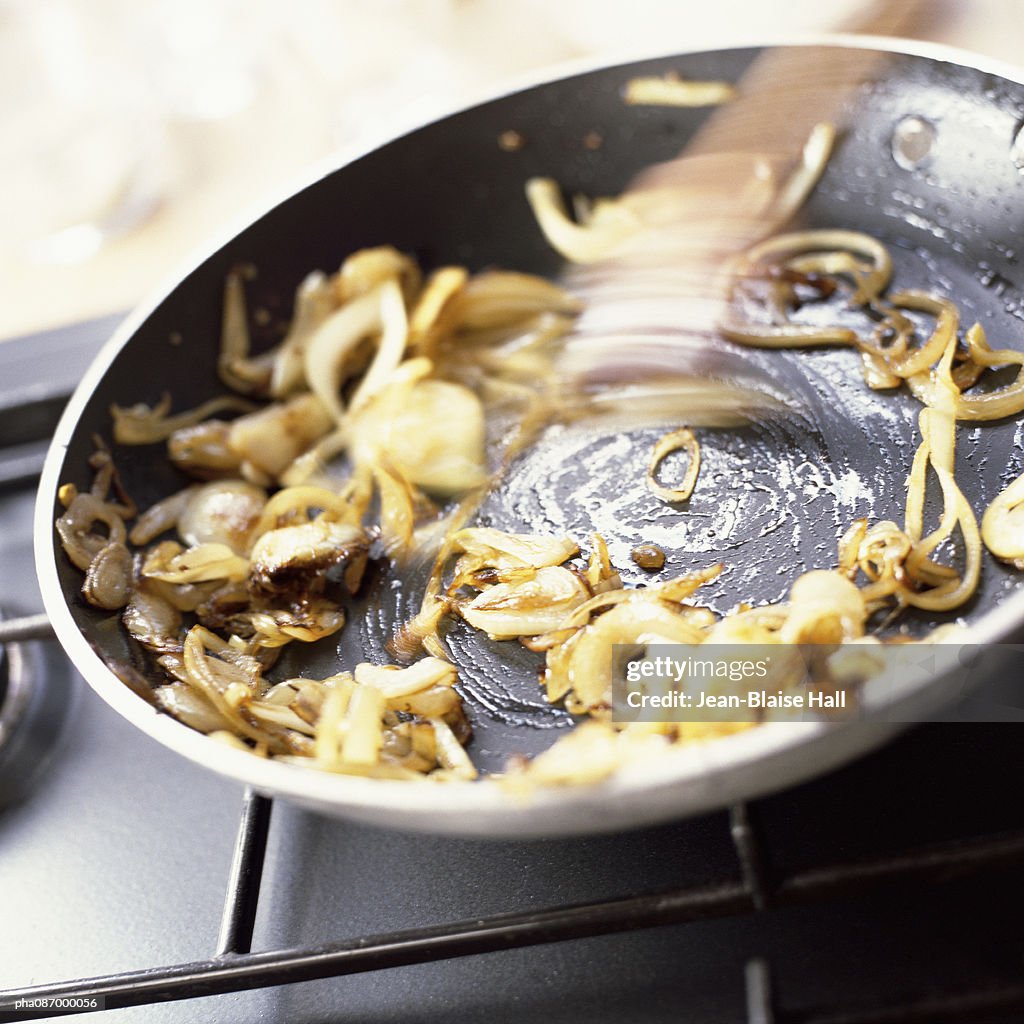 Close-up of onions being grilled in a pan.