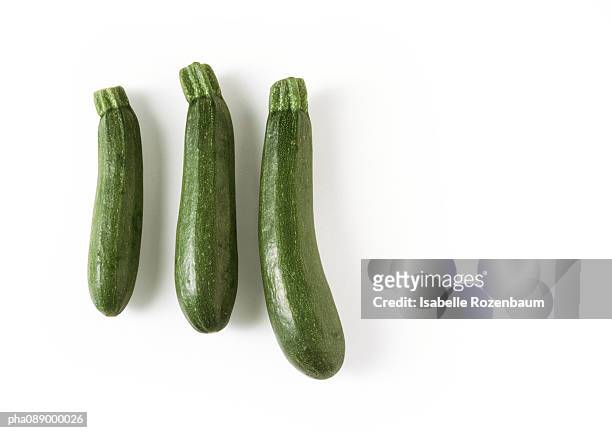 three zucchini, full length - courgette stock-fotos und bilder