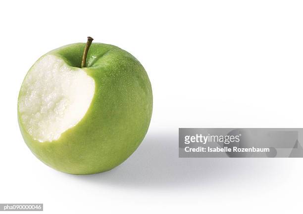 green apple bitten, granny-smith, white background - apple bite out stock pictures, royalty-free photos & images