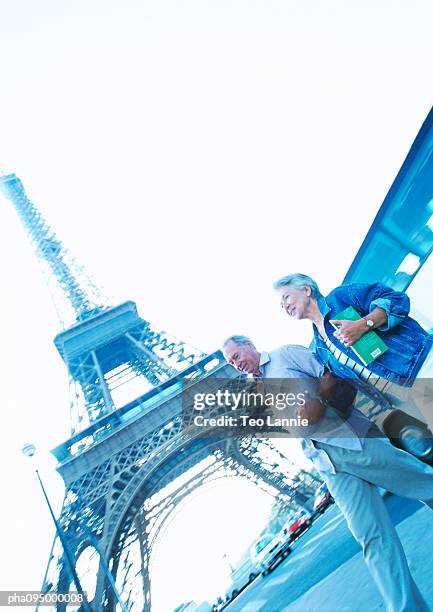 france, paris, mature woman and man in front of eiffel tower - travel11 stock pictures, royalty-free photos & images