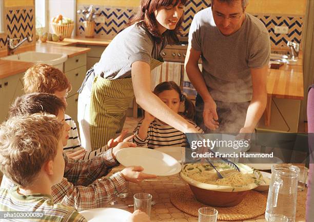 man and woman serving children at table - large family bildbanksfoton och bilder
