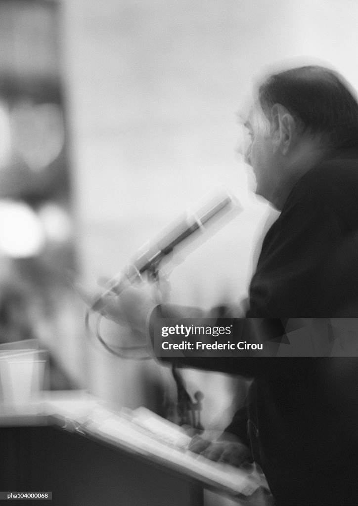 Man holding microphone, blurred, b&w