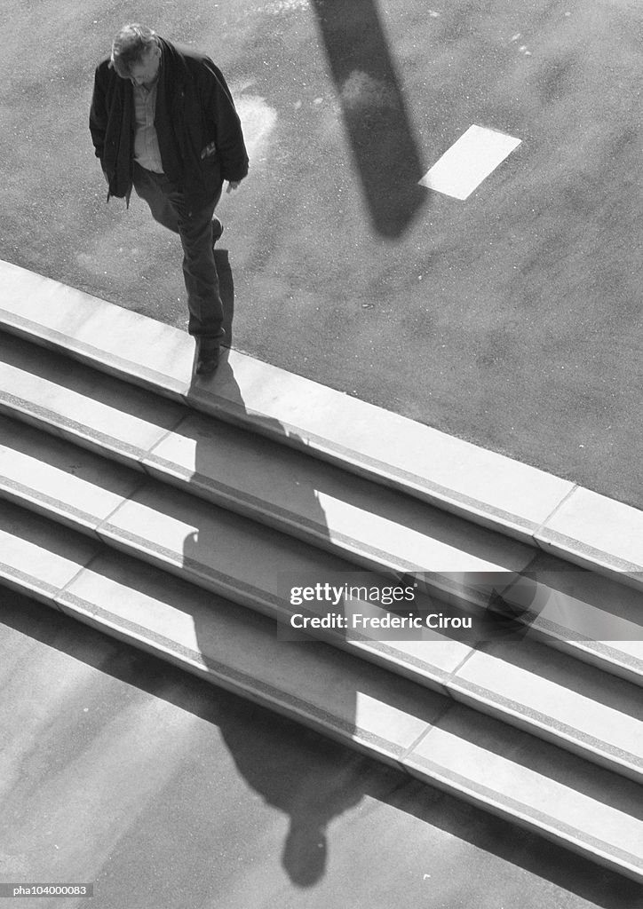 Man walking down stairs, elevated view, b&w