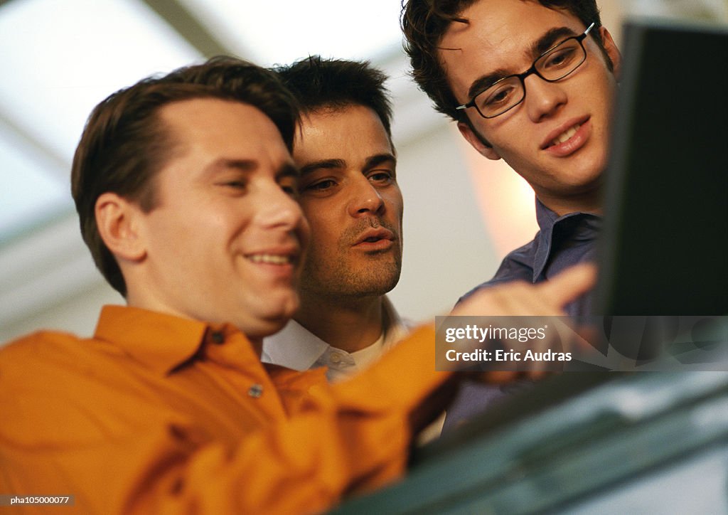 Three men looking at laptop