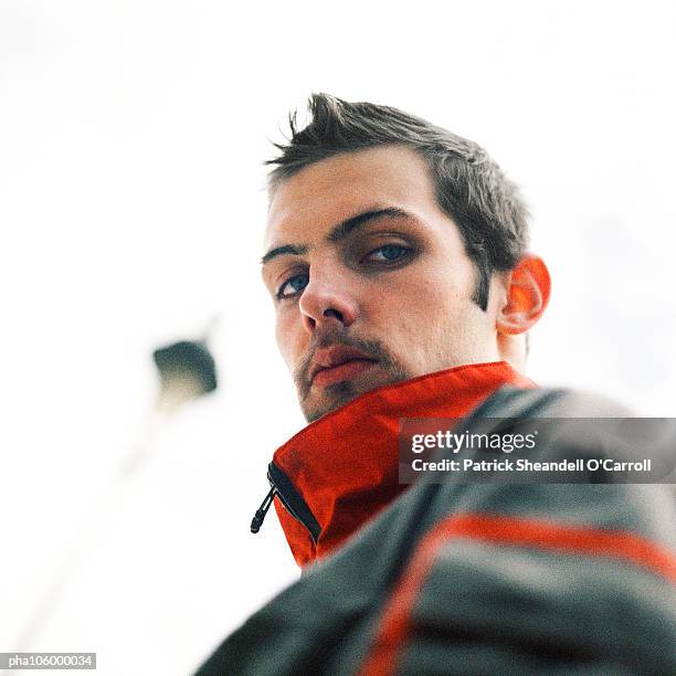 young man looking into camera, close-up, low angle view - 無礼 ストックフォトと画像