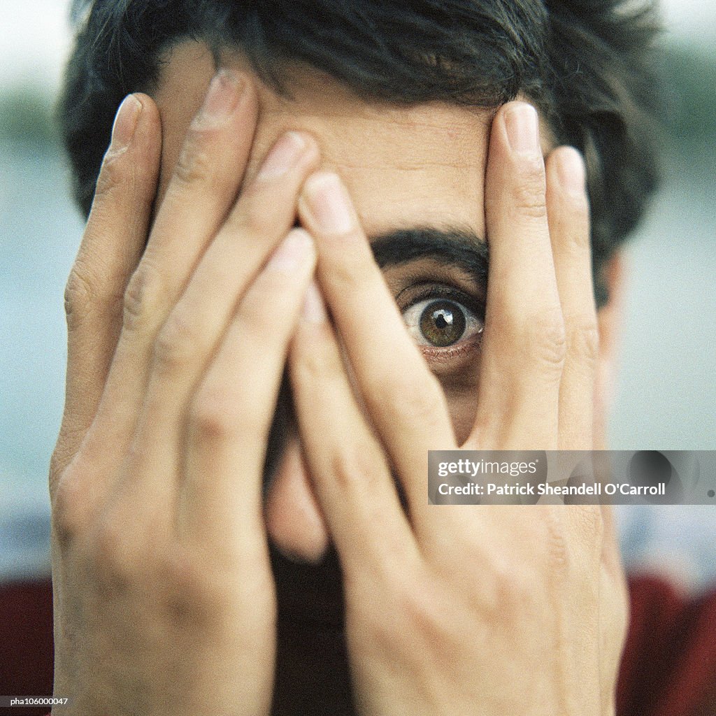 Teenager with hands on face