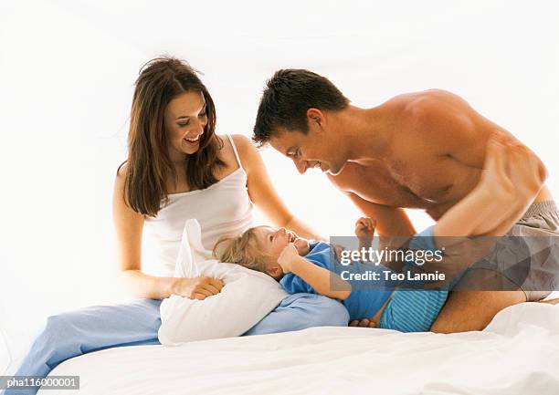 couple and child on bed, smiling - knickers girl stock pictures, royalty-free photos & images