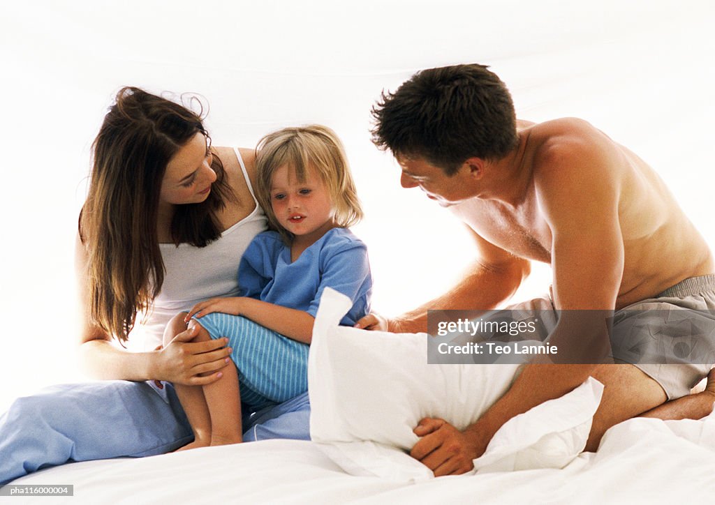 Couple and child on bed