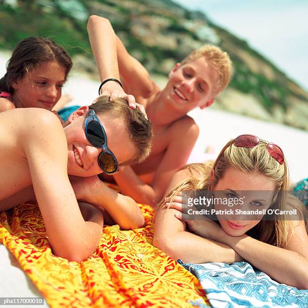 teenagers laying on beach towels - travel12 stock pictures, royalty-free photos & images